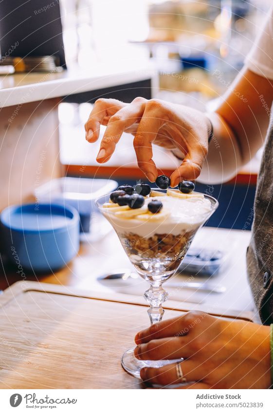 Woman preparing fruit and berry dessert woman waitress food sweet bowl fresh organic blueberry meal nutrition red natural cereal vegetarian cream delicious