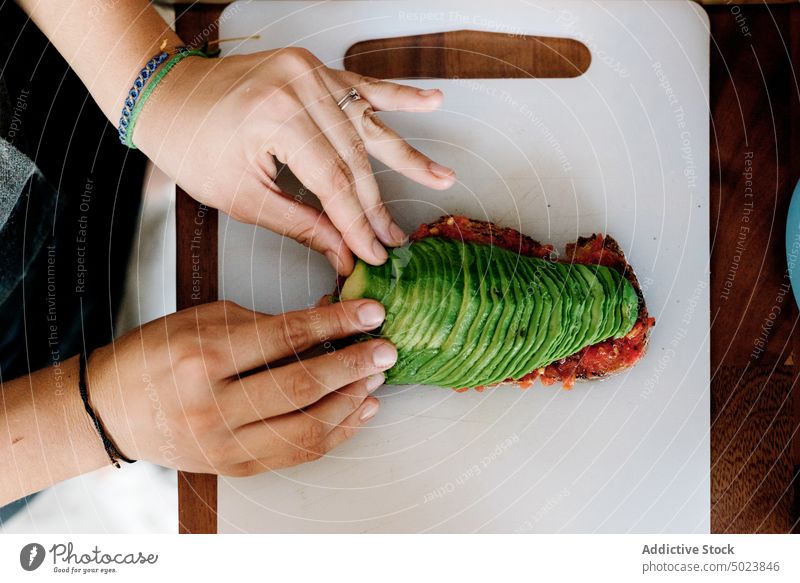 Person putting sliced avocado on bread in white stand sandwich food lunch stack healthy meal delicious snack nutrition fresh breakfast toast taste vegetarian