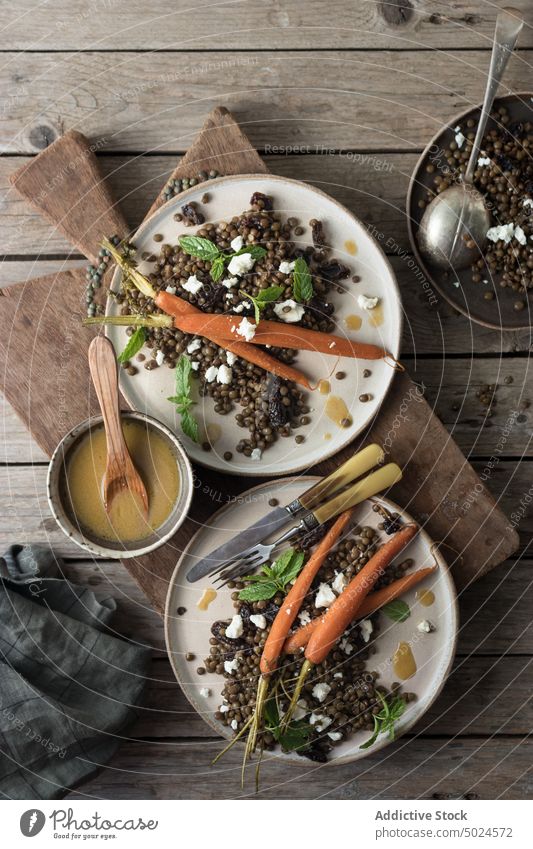 Served plates of organic salad on wooden table lentils served carrot dressing green rustic board fresh layout sauce culinary cheese mint recipe gourmet