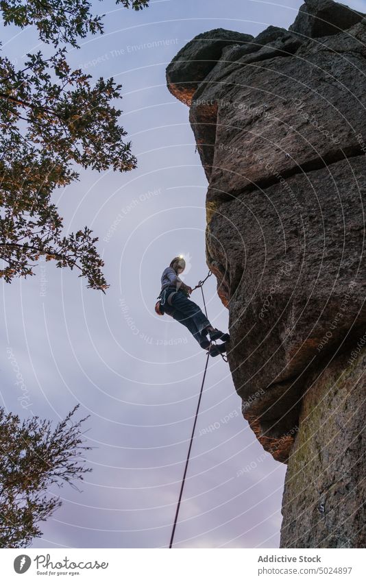 Courageous male climber hanging on cliff mountain man equipment hiking climbing rescue rock danger extreme sport protect safety leader trust protection rope