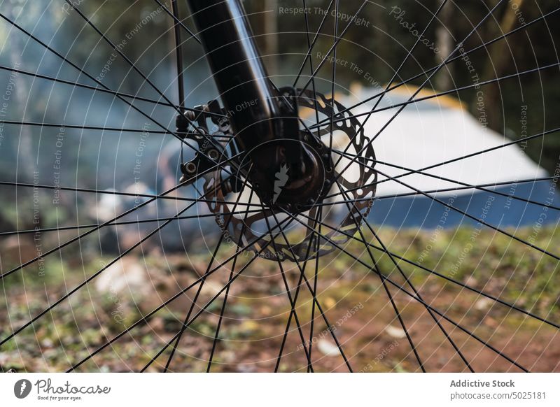 Wheel of bicycle against tent and trees in forest wheel detail part adventure camp tourism nature woods recreation traveler campfire bonfire campsite tourist