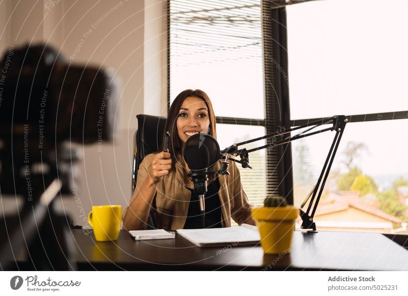 Woman on radio station writing on a notepad woman host headphones microphone take note notebook broadcast female blog pen write record workplace wireless