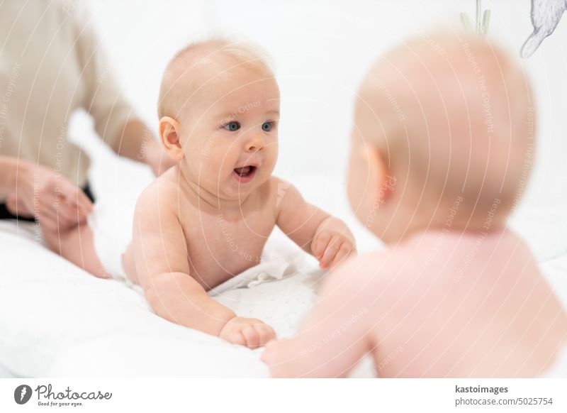 Beautiful shot of a cute baby boy looking at his reflection in big mirror. child portrait play infant childhood beautiful adorable emotion smile happy innocent