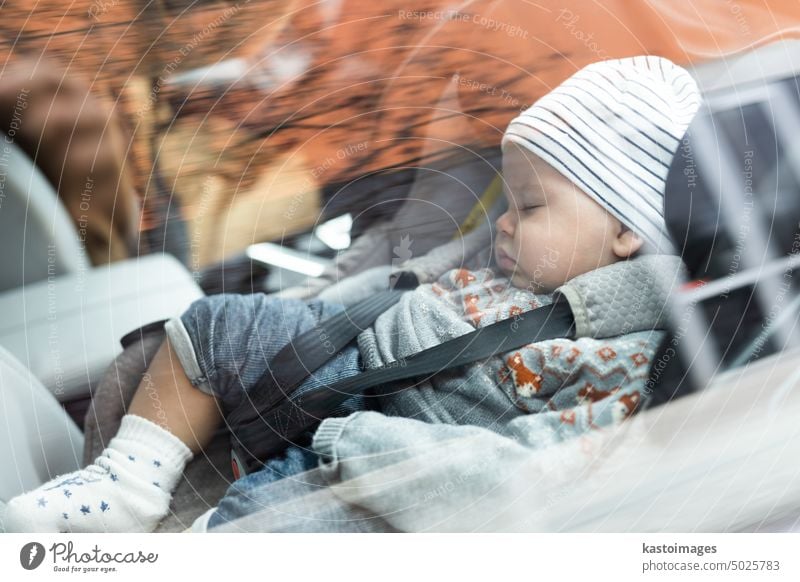 Cute little baby boy sleeping strapped into infant car seat in passenger compartment during car drive. vehicle child transportation safety protection people