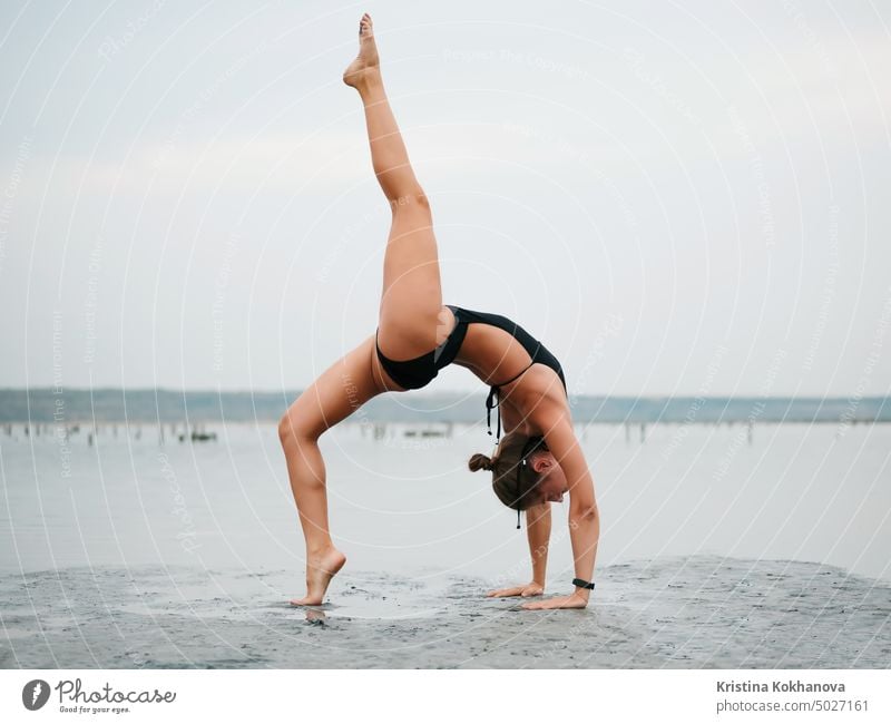 Young woman practicing yoga in water estuary, lake or river. Asana, balance. Fitness, sport. healthy lifestyle concept. adult beach beautiful beauty body