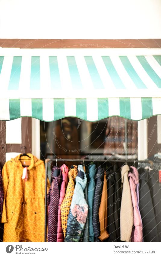 Jackets on a stand in front of a clothing store Fashion shop Hallstand Shopping Retail sector garments business Trade Shop window Store premises Clothing