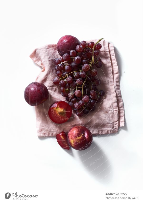 Flatlay with plums and grapes top view on white background. nature juicy branch agriculture nutrition closeup group bright health farm composition monochrome