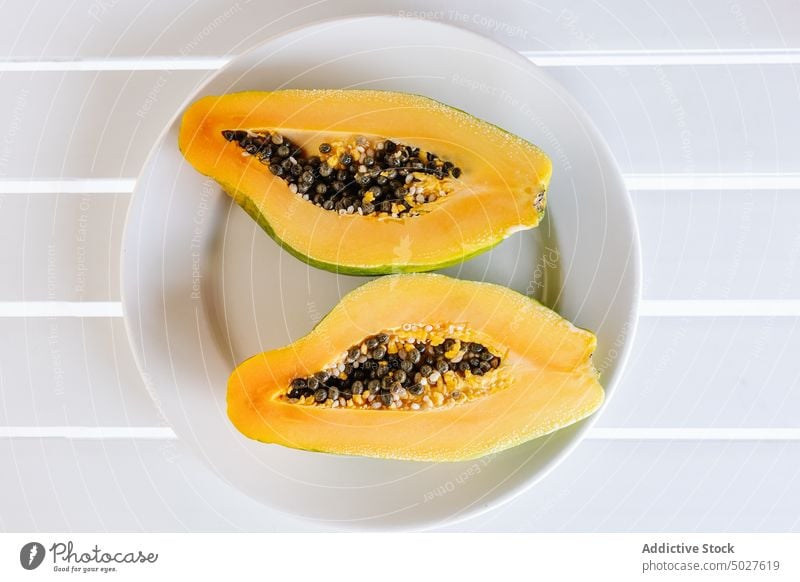 Ripe halved papaya placed on white ceramic plate fruit exotic tropical vitamin food fresh healthy food sweet seed ripe tasty nutrition cut half summer