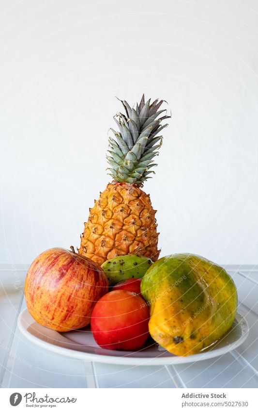 Plates of assorted exotic fruits and juice bottle served on table tropical papaya apple cactus fruit mango refreshment vitamin summer resort healthy food