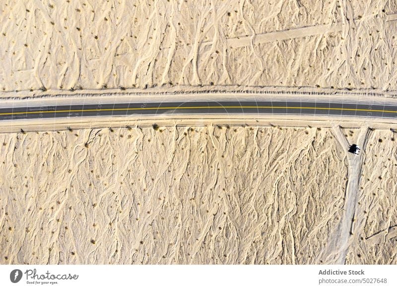 Drone view of asphalt road going through sandy valley in California highway mountain Death Valley landscape roadway National Park scenery route nature highland