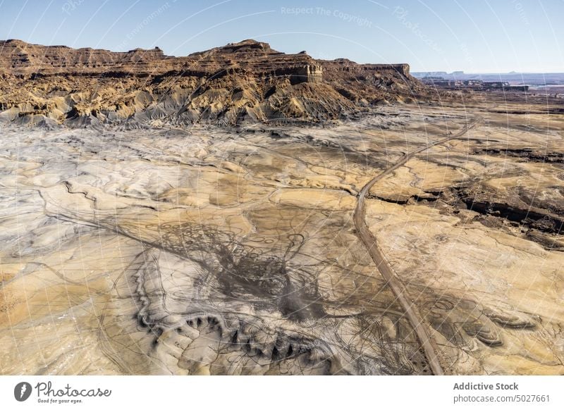 Rocky hill in desert valley against blue sky in USA cliff landscape nature arid Glen Canyon National highland terrain dry picturesque breathtaking slope