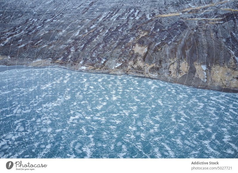 Frozen lake in mountains in winter ice glacier frozen nature north background geology slope cold environment weather rough season scenic snow arctic abstract