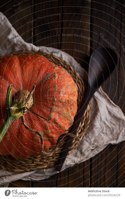 Whole pumpkin on wooden table fruit squash gourd farm ripe food spoon harvest agriculture uncooked halloween placemat edible vitamin whole autumn raw rustic