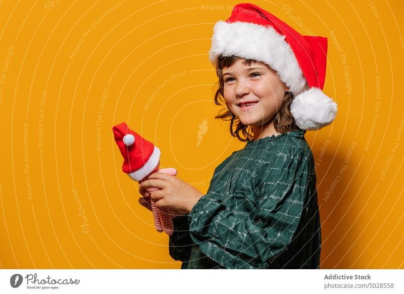 Girl standing with crochet toy on Christmas eve girl share christmas celebrate holiday colorful bright santa hat costume kid vivid style smile dress child happy