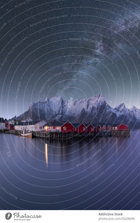 Starry sky above mountainous village near lake milky way highland house night lofoten islands norway star starry reflection spectacular picturesque vivid scenic