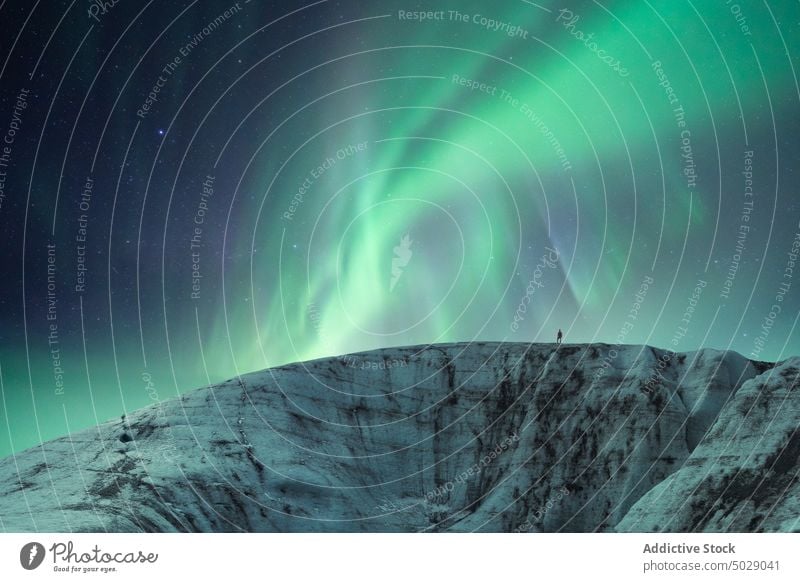 Traveler against night sky with glowing polar lights aurora borealis glacier northern ice formation traveler winter cold frozen iceland vatnajokull green