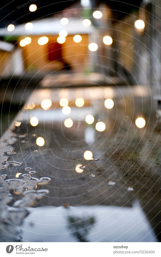 Abstract defocused rain puddle on the table. Wet tables closeup in cafe during heavy rain wet raindrop water weather background outside abstract pattern patio