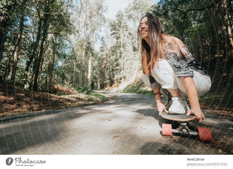 Sporty woman riding on the skateboard on the forest road. Longboarding, female.Gen Z sport activity motion people adult lifestyle skateboarding outdoor