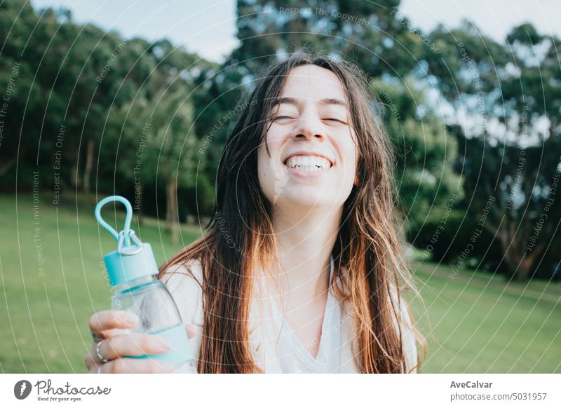 Portrait young woman greeting to camera holding a bottle of water for the dog, wide angle lens image pet affection animals best bonding close up collar emotions