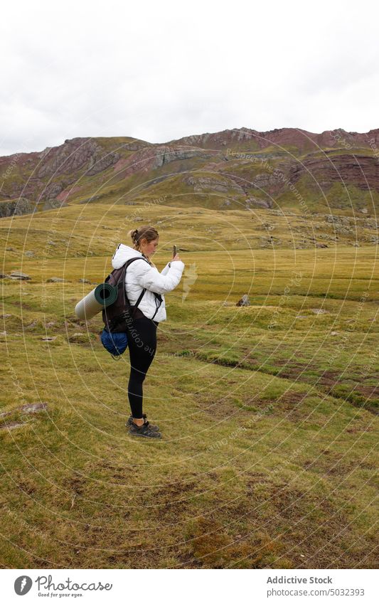 Female traveler taking photos of mountains woman take photo hike valley smartphone summer ridge nature weekend female cloudy sky explore shoot trip overcast