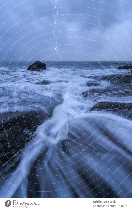 Lightning flashing above stormy sea on cloudy day lightning thunderstorm landscape sky dramatic scenic ocean nature energy picturesque weather marine water rock