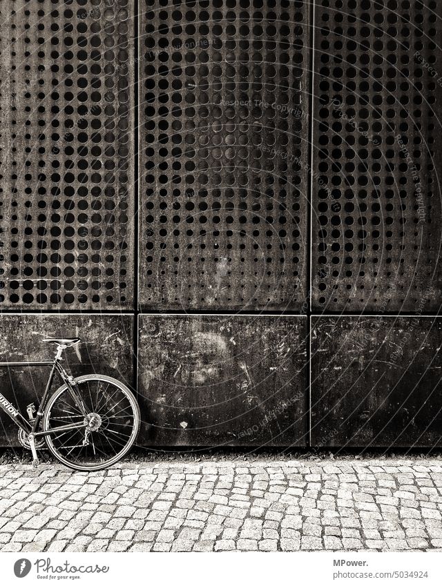 rusty wheel on rusty house wall Bicycle Old Rust off Paving stone façade perforated Metal Means of transport Cycling Exterior shot Deserted Detail