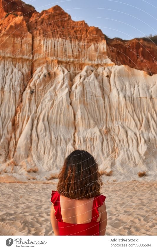 Female tourist standing near cliff woman beach summer sand shore vacation weekend falesia algarve portugal female brunette swimwear travel sandstone coast