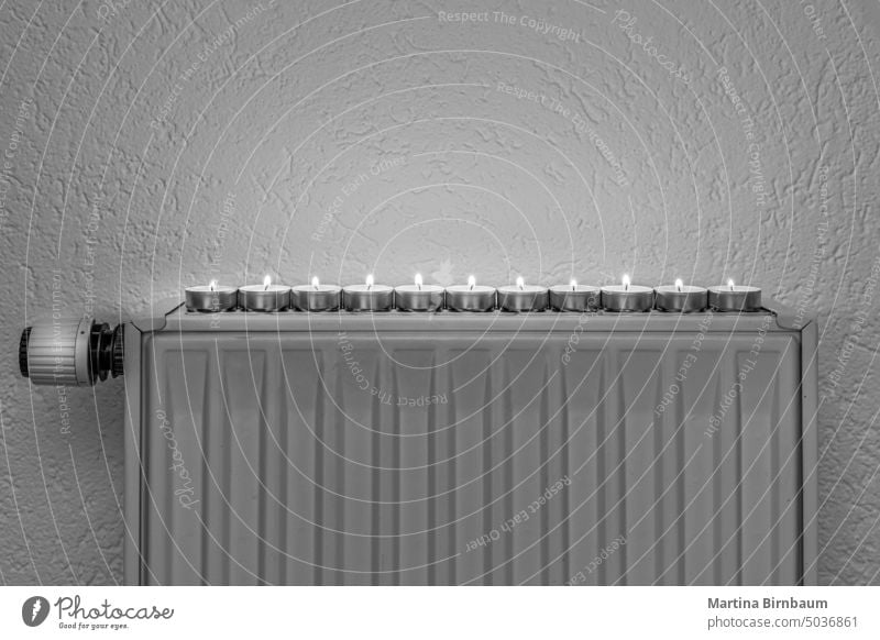 Tea candles on a wall heater, concept of alternative heeating possibilities during the energy crisis and turning down the regular heating sources oil gas