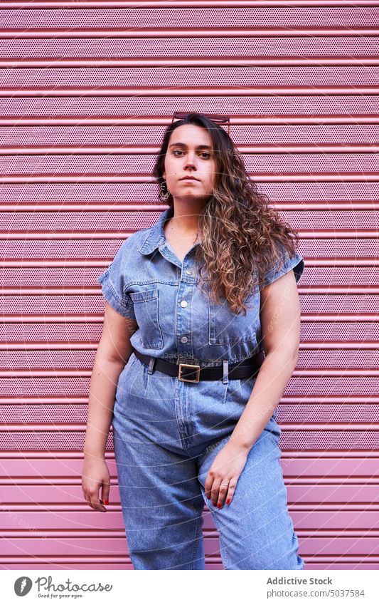 Woman standing near pink wall woman street building style urban madrid spain female brunette lifestyle young daytime summer daylight pink background outdoors