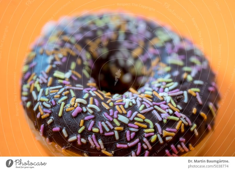 A chocolate donut doughnut Chocolate donut biscuits Perforated doughnuts sweet dish cute Granules Coulored sugar candy variegated Food shallow depth of field