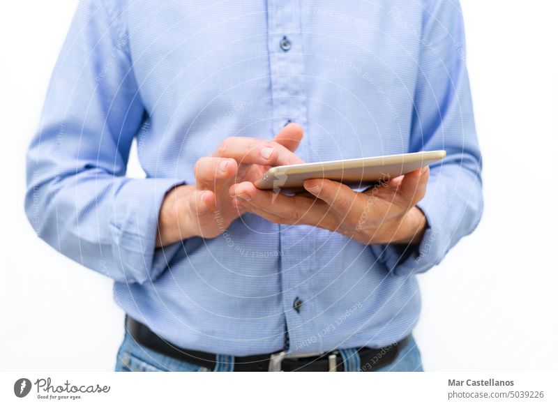 Man with tablet in hands and blue shirt on white background. Copy space. man body parts internet consult online look electronics person technology business