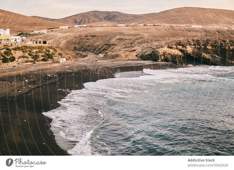 Amazing landscape with foamy ocean and black sandy coast beach nature volcanic picturesque sunset seascape scenery hill viewpoint border fuerteventura