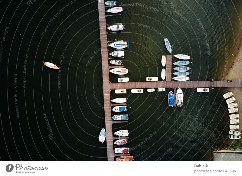 Aerial top view of boats near wooden pier at lake yacht water vessel sailboat motorboat harbor aerial view marina travel sea luxury drone marine port harbour