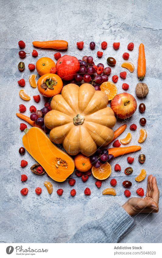 Raw pumpkins and assorted autumn veggies vegetable hand fall still life apple persimmon harvest fresh food raw dark background healthy natural various colorful