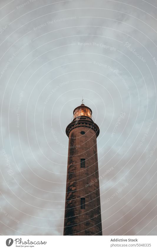 Lighthouse against cloudy gray sky lighthouse weather tower navigate guide landmark building maspalomas gran canaria canary islands spain gloomy dull