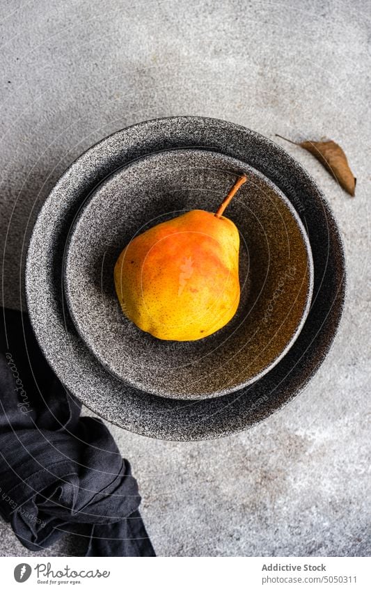 Bowl with organic pears autumn bowl ceramic crop dark dessert eat eating fall food fruit grey harvest healthy meal minimalistic napkin set setting stoneware