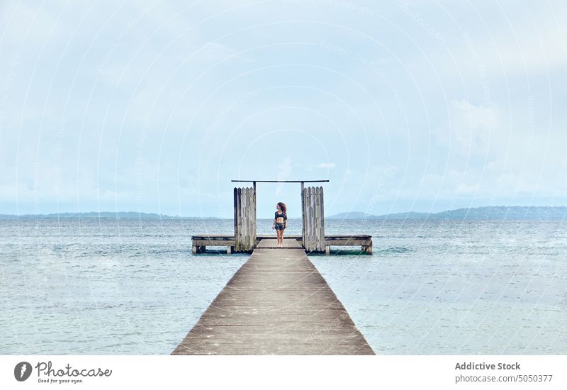 Woman on quay of sea woman pier freedom boardwalk carefree vacation water travel ocean nature summer waterfront seafront holiday coast relax seaside seashore