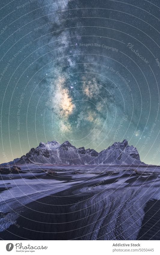 Ice pieces on black sand beach against mountains under milky way sky frozen black beach ice winter snow stockness vestrahorn ridge scenery star frost night