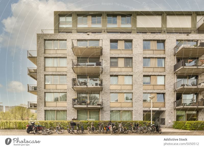 Modern building under a sky with clouds street sidewalk house architecture city pavement town day urban outdoors road cityscape community no people window home