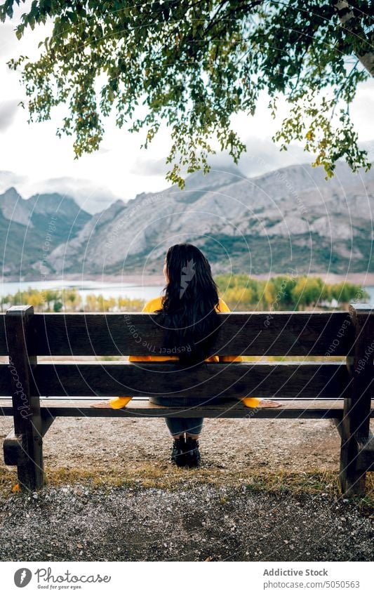 Woman sitting on bench near mountainous lake woman enjoy admire valley nature highland view calm serene tranquil amazing peaceful traveler ridge scenic