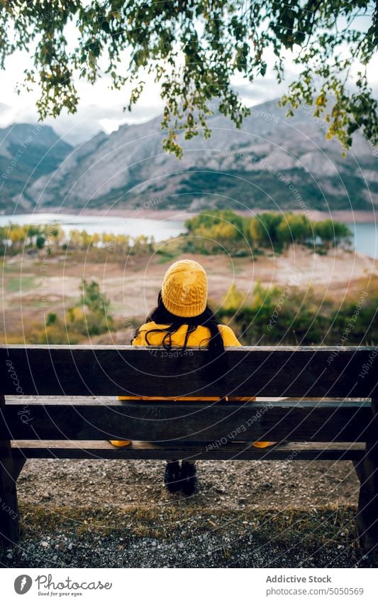 Woman sitting on bench near mountainous lake woman enjoy admire valley nature highland view calm serene tranquil amazing peaceful traveler ridge scenic