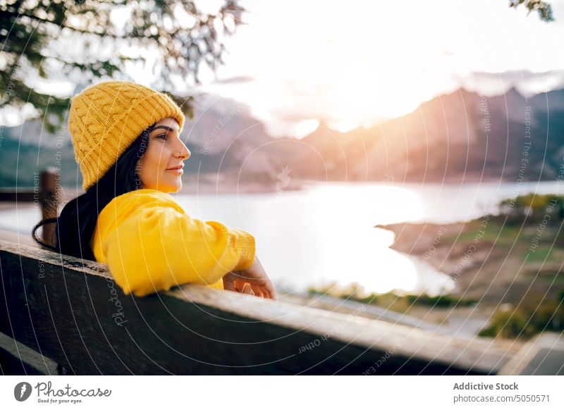 Woman sitting on bench near mountainous lake woman enjoy admire valley nature highland view calm serene tranquil amazing peaceful traveler ridge scenic