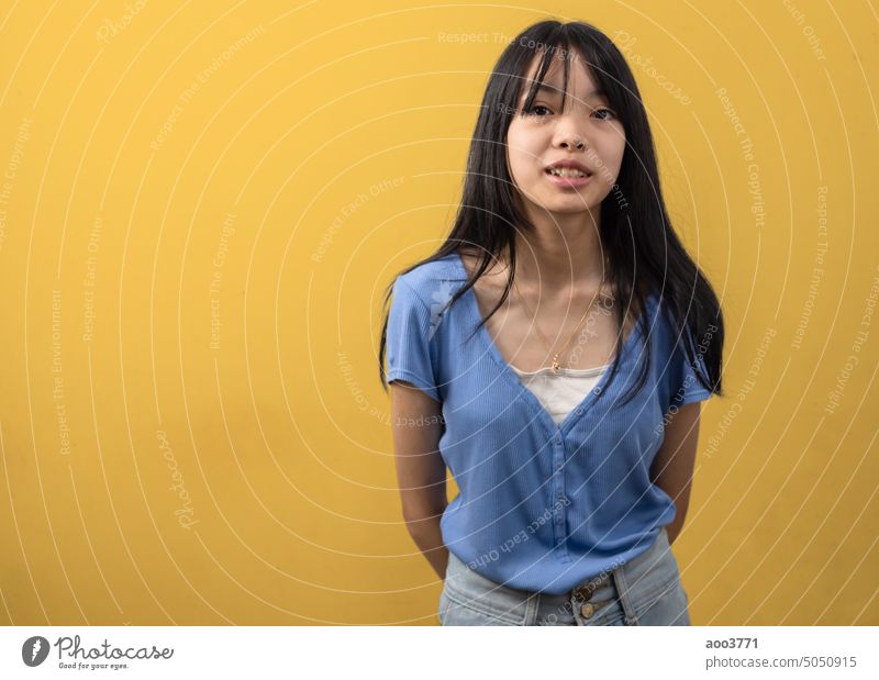 asian girl smiling. lifestyle beauty and fashion on yellow background.copy space. smile smiles portrait standing model child cute female happy young happiness