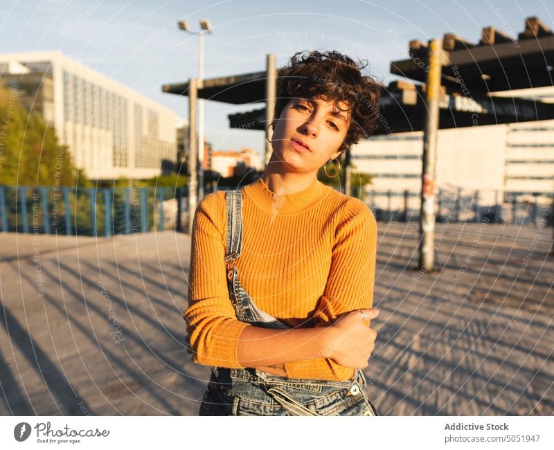 Pensive woman standing on sunny street thoughtful pensive calm sunlight casual shadow city urban personality female alone short hair serious individuality