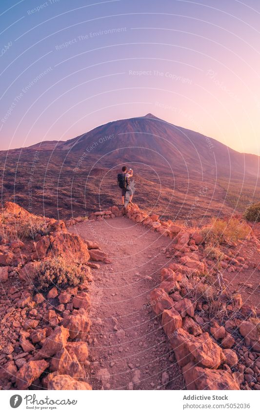 Unrecognizable traveler taking picture of volcano in Tenerife man tourist take photo mountain nature picturesque tenerife spain explore cliff highland trip