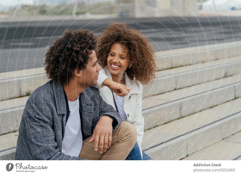 Smiling black couple talking on steps cheerful together vacation summer tourist city enjoy relationship smile travel stair happy casual boyfriend girlfriend man