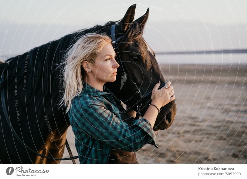 Portrait of adult woman with beautiful horse in nature. Sunlight, silhouette.Concept of love for lesser brothers, caring and animal training outdoor equestrian