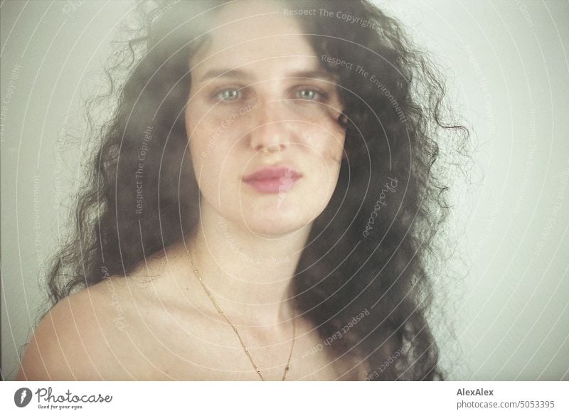 Close up smoky portrait of young dark haired woman with curls, light blue eyes and freckles Woman Young woman Freckles Curl Brunette long hairs pale pretty Skin