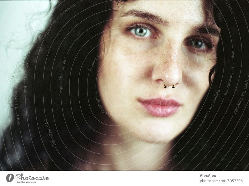 Close portrait of young dark haired woman with curls, light blue eyes and freckles Woman Young woman Freckles Curl Brunette long hairs pale pretty Skin Face