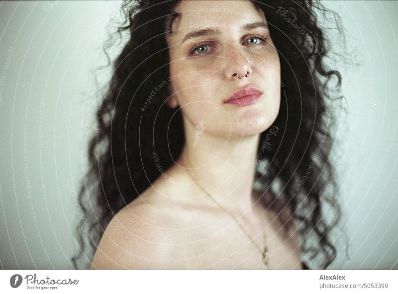 Close portrait of young dark haired woman with curls, light blue eyes and freckles Woman Young woman Freckles Curl Brunette long hairs pale pretty Skin Face